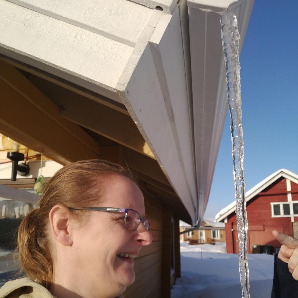A long icicle hanging from a roof edge in Lapland in April, formed by daytime melt and nightly re-freezing.