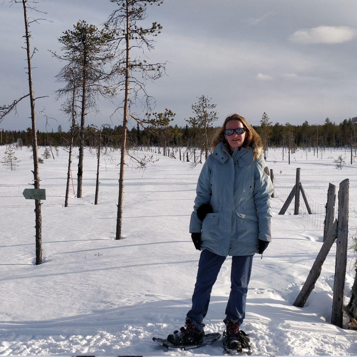 Belgische illustratrice op sneeuwkorst met sneeuwschoenen, Fins Lapland lente